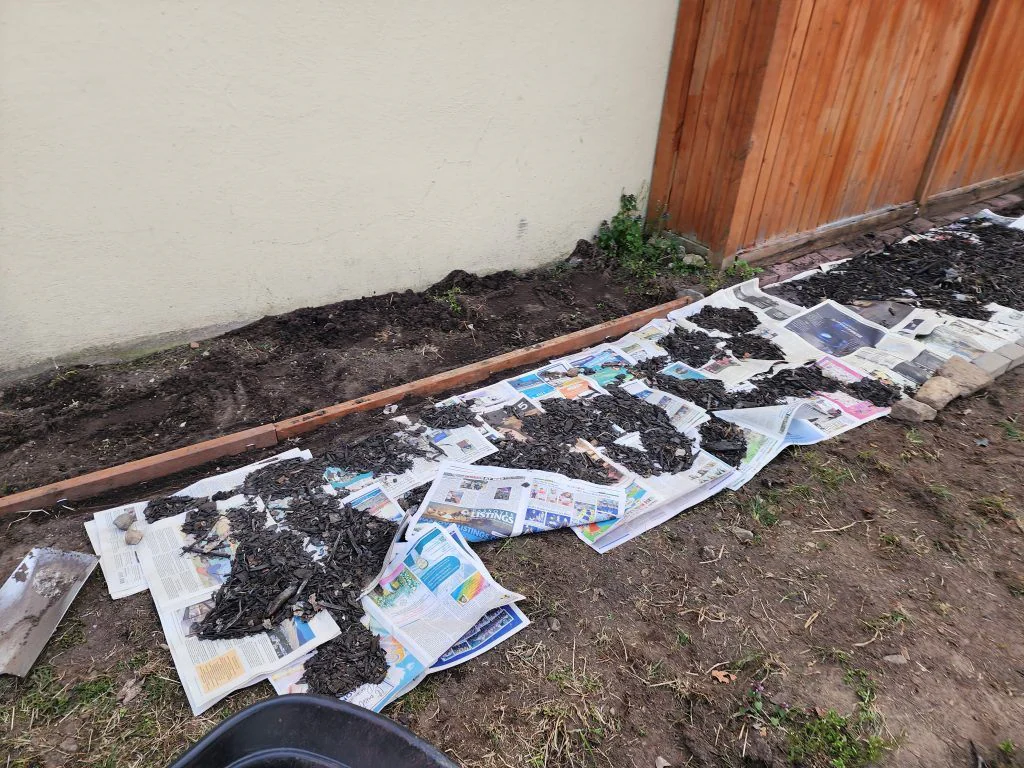 Three sealed 2x4 boards set into a shallow trench as a path border