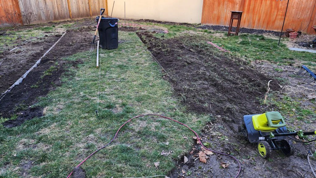 Wide view of both sides of the new lawn strip being tilled to create planting beds